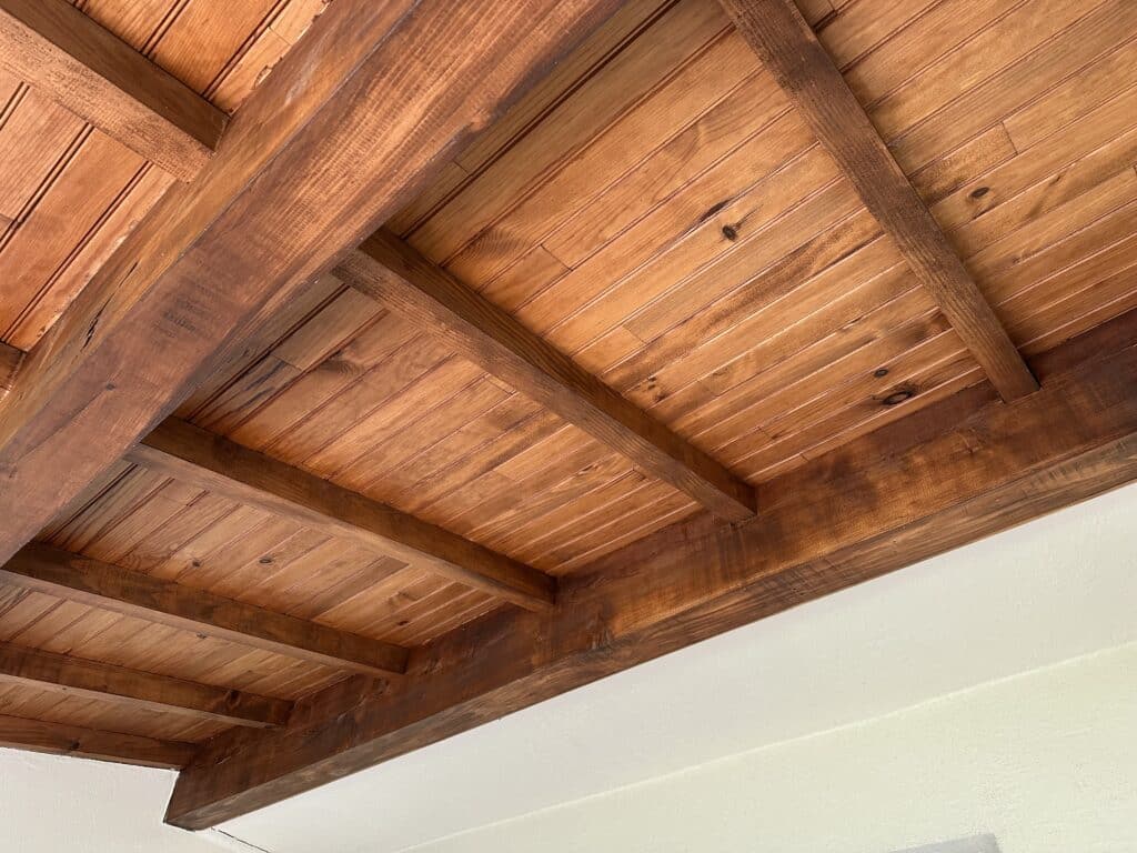 Gros plan sur une charpente en bois d'une habitation, zone ciblée pour le traitement contre les fourmis charpentières.